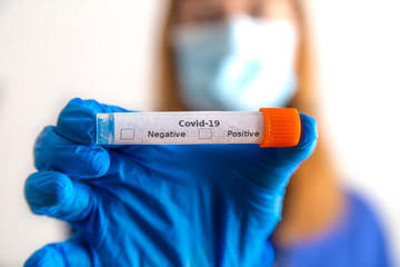 eine Ärztin hält ein Abstrichröhrchen mit Coronavirus in der Hand
