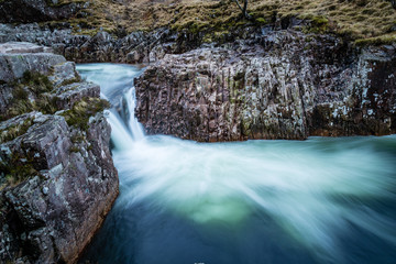 long exposure shot of the waterfalls in glen etive near loch etive and the entrance to glencoe and rannoch moor in the argyll region of the highlands of scotland during winter