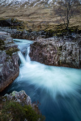 long exposure shot of the waterfalls in glen etive near loch etive and the entrance to glencoe and rannoch moor in the argyll region of the highlands of scotland during winter