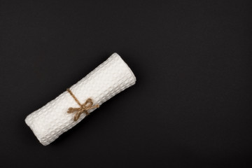 Tied with rope and a towel roll on a black background.