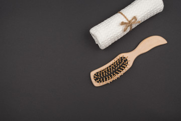 A comb and a towel roll on a black background.