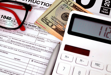 Income tax form with with calculator and money