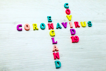 Coronavirus COVID-19 in ENGLAND - Rainbow colored wood letters on grey wooden background