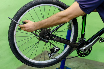 Naklejka premium bicycle repair. mountain bike in the workshop. Rear derailleur adjustment
