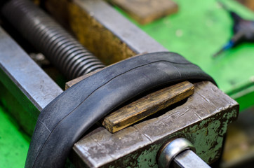 Repairing bicycle tube In workshop. Close up image of glue to repair inner tube of bicycle wheel. The mechanic does his job thoroughly.