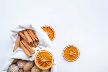 Eco bag with walnut, dry orange and cinnamon on white background