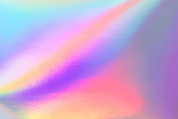 Abstract trendy rainbow holographic background in 80s style. Blurred texture in violet, pink and mint bright neon colors.
