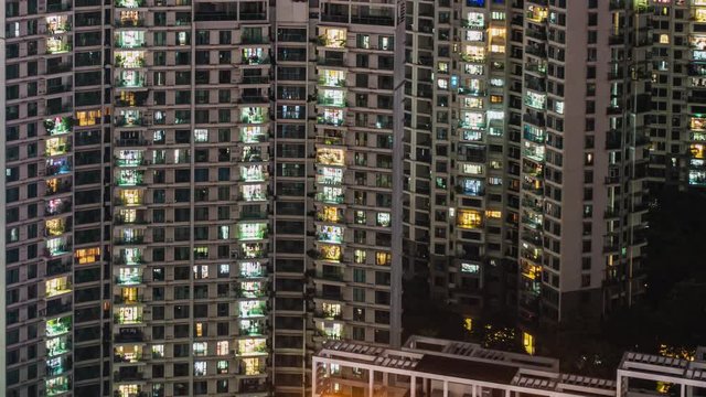 Night timelapse of massive apartments.Timelapse of residential flats windows lighting up and turning off overnight in Shenzhen, China. Modern life in crowded massive apartment buildings.