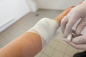 A doctor puts on a pressure bandage in a hospital