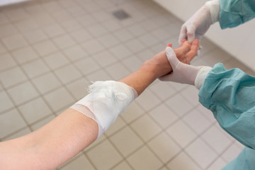 A doctor puts on a pressure bandage in a hospital