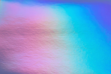 Abstract trendy rainbow holographic background in 80s style. Blurred texture in violet, pink and mint bright neon colors.