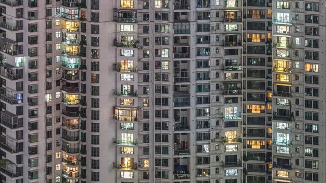 Time lapse of many apartment windows in downtown. Timelapse of residential flats windows lighting up and turning off overnight in Shenzhen, China. Modern life in crowded massive apartment buildings.