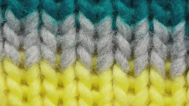 Fibers of knitted clothes with multi-colored threads. Stretching fibers of knitted fabric threads macro. Looped footage