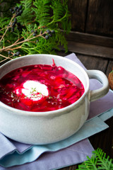Traditional organic beetroot soup - borscht or borshch with meat over wooden background, vertical image