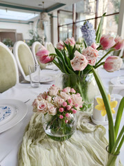 Table set for an event party or wedding reception - fresh rose flowers in vase