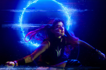 Cyberpunk style portrait of beautiful young girl poses underwater against glowing circle. Picture has noir tones