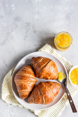 Fresh croissants. Freshly baked french croissants with jam on light grey background. Top view.