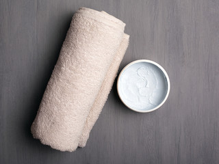 rolled folded towel and scrub on a gray background top view close-up