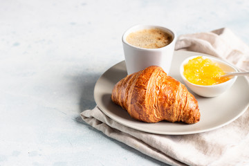 French breakfast with fresh pastries. Croissants with coffee and jam. Light grey stone background. 
