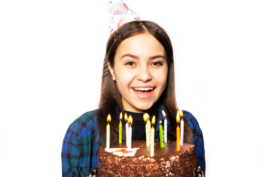 A Young Russian Girl Celebrates Her Eighteenth Birthday. Birthday Girl Of 18 Years With A Cake Smiles And Looks Into The Frame On A White Background.