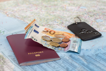 Papierowa mapa samochodowa na której leży paszport banknoty i monety euro oraz karta do samochodu. - obrazy, fototapety, plakaty