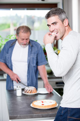 Two generations of men cooking together. 
