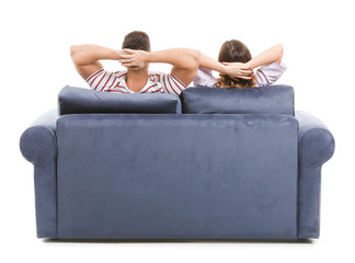 Young couple sitting on sofa against white background, back view