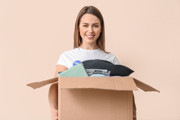 Volunteer with donations for poor people on color background