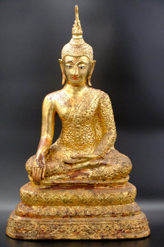Gold Buddha image sitting in Meditation on black background