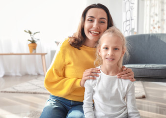 Young woman and her little daughter video chatting at home