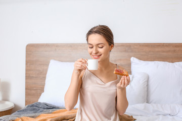 Morning of beautiful young woman having breakfast in bed