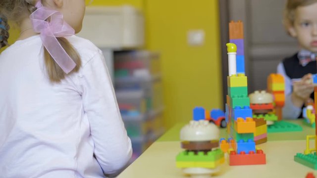 Children in the classroom make figures with teacher. Modern technology concept