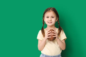 Cute little girl with sweet chocolate egg on color background