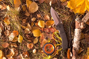 Travel knife and compass for orientation. Orientation on the ground.
