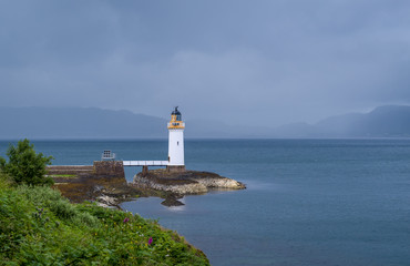 Nothern sea at cloudy weather and Tobermory Lighthouse. Island of Mull, Scotland