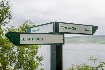 Fototapeta premium Tobermory tracking paths sign pointing to lighthouse and viewpoint. Island og Mull, Scotland,
