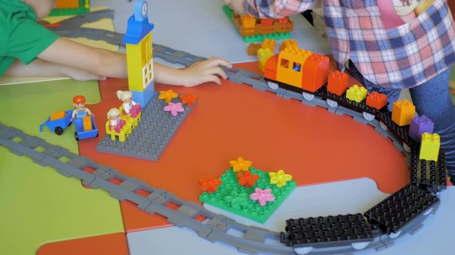 Children in the classroom make figures with teacher. Modern technology concept