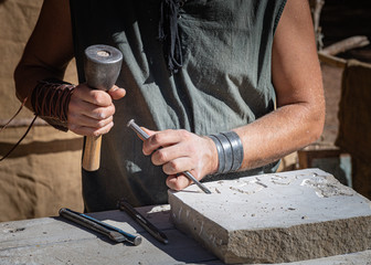 stone craftsman working in his stonekeeping workshop.. - obrazy, fototapety, plakaty