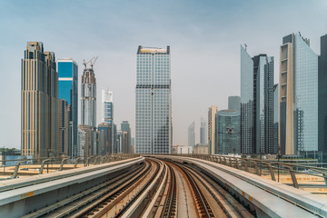Fototapeta na wymiar Dubai metro railroad at skyscrapers buildings skyline background.