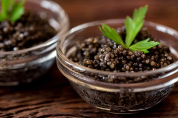 Black surgeon or beluga caviar on wooden table