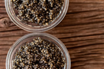 Top view of black surgeon or beluga caviar on wooden table