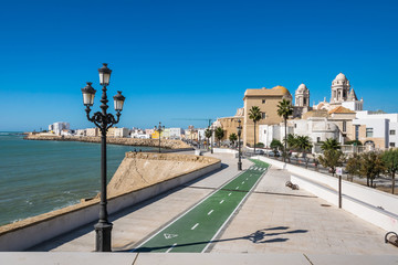Fototapeta premium Seaside road Avenida Campo del Sur with the Catedral de Cadiz in Spain