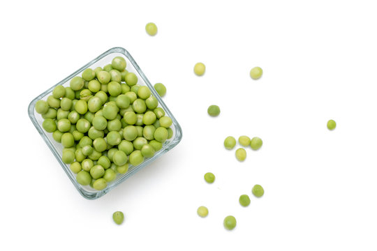 Chicharos  pelados en un recipiente de cristal con unos chicharos con cascara a un costado sobre un fondo blanco