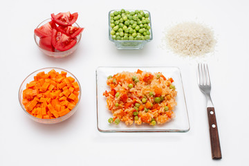Arroz rojo o a la Mexicana acompañado de sus ingredientes de preparación sobre un fondo blanco y un tenedor