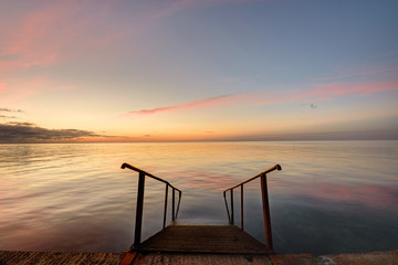 Beautiful view of the evening sea, in the foreground of the stairs descendinto the sea