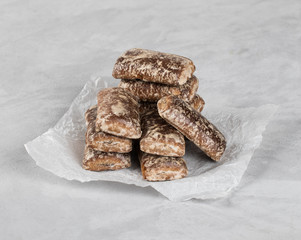 Chocolate gingerbread cookies with icing sugar on a light background