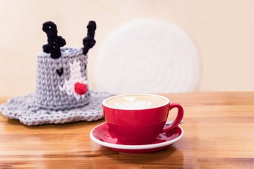 Red cup of coffee cappuccino and cute decorative knitted basket