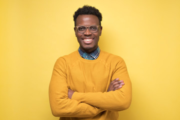 Smiling african american young man inyellow sweater smiling confident at camera.
