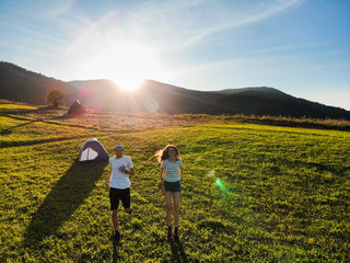 Aerial view of love couple of hikers spend time together away from city bustle by sunrise in...