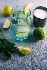 fresh homemade mojito surrounded by lemon and peppermint on wooden table. Copyspace